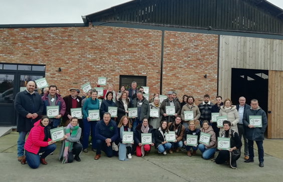 Groepsfoto van de Limburgse zorgboeren en -boerinnen met hun uithangbord